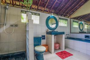 a bathroom with a shower and a toilet and a sink at Sari Bamboo Bungalows in Ubud