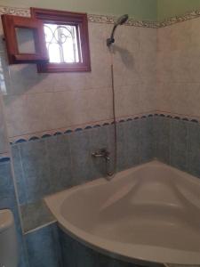 a bath tub in a bathroom with a window at Apartment El Jadida in El Jadida