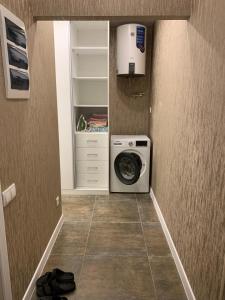 a laundry room with a washing machine and a closet at Апартаменты в центре города in Bishkek