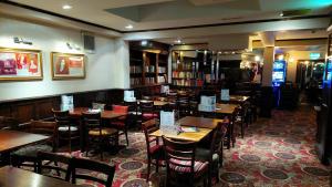 a restaurant with tables and chairs in a library at George Hotel Wetherspoon in Bewdley