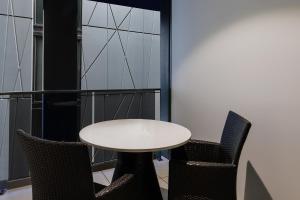einen weißen Tisch und zwei Stühle in einem Zimmer in der Unterkunft Meriton Suites Canberra in Canberra