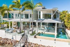 a house with a swimming pool and palm trees at 12 Noosa Parade, Noosa Heads in Noosa Heads