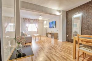 een woonkamer met een bank en een tafel bij Lujoso apartamento en el centro de la ciudad in Murcia