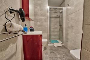 uma casa de banho com um chuveiro, um lavatório e um WC. em Lujoso apartamento en el centro de la ciudad em Múrcia