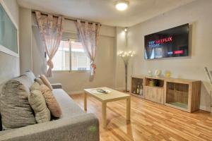 een woonkamer met een bank en een tafel bij Lujoso apartamento en el centro de la ciudad in Murcia