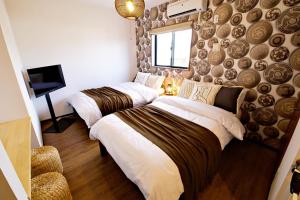 een slaapkamer met 2 bedden en een muur bij クラリス Ⅱ RoomE in Ishigaki Island