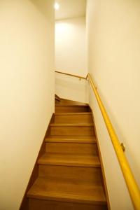 石垣島にあるクラリス Ⅱ RoomEの黄色いレールが付いたウッドフロアの建物内の階段