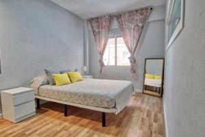 een slaapkamer met een bed met gele kussens en een spiegel bij Lujoso apartamento en el centro de la ciudad in Murcia
