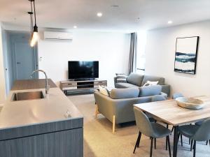 a kitchen and living room with a table and a couch at Qube Broadbeach in Gold Coast