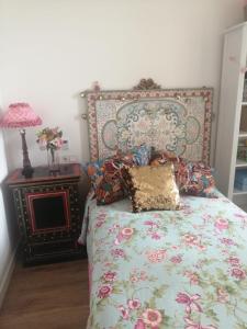 sypialnia z łóżkiem z kwiatową narzutą i stołem w obiekcie Inmejorable en el Puerto Deportivo a 1 minuto de la playa. Pleno centro w mieście Gijón