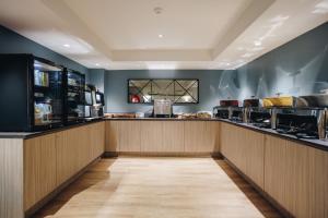 a restaurant with a counter with food on it at Banjo Paterson Inn in Jindabyne