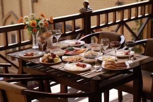 a table with plates of food and wine glasses at Arkanchi Hotel in Khiva