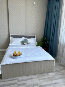 uma cama com um prato de comida e dois copos de sumo de laranja em ExpoNewLife2 em Astana