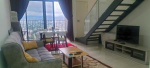 - un salon avec un canapé et une télévision dans l'établissement MLH Designer Duplex Suite @ EkoCheras, à Cheras