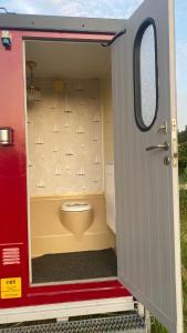 a small bathroom with a toilet inside of a trailer at Aspö Glamping in Drottningskär