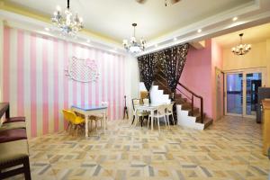 a dining room with pink walls and a table and chairs at Haige Homestay in Taitung City