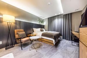 a bedroom with a bed and a table and a chair at The Post Hotel in Seoul