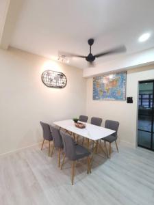 a dining room with a white table and chairs at Wellson Home Ipoh 6 (15px+)温馨舒适奶油风民宿15人 in Ipoh