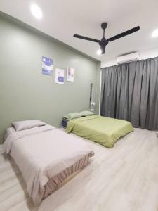 a bedroom with two beds and a ceiling fan at Wellson Home Ipoh 6 (15px+)温馨舒适奶油风民宿15人 in Ipoh