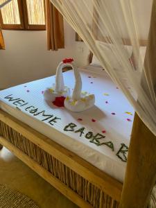 Una cama con un feliz año nuevo escrito en ella en Baobab Africa Lodge Zanzibar en Mtende