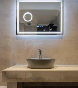 a sink in a bathroom with a mirror above it at Velky Sen Luxury Apartments in Sarti