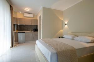 a bedroom with a large bed and a kitchen at Velky Sen Luxury Apartments in Sarti