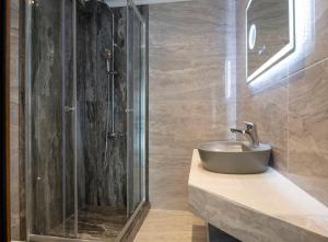 a bathroom with a sink and a shower at Velky Sen Luxury Apartments in Sarti