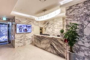 a lobby with marble walls and a reception counter at The Post Hotel in Seoul