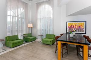 una sala de espera con sillas verdes y una pintura en Holiday Inn Express Miami Airport Doral Area, an IHG Hotel en Miami