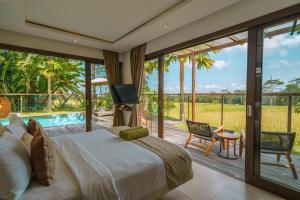 1 dormitorio con 1 cama y balcón con piscina en K Club Ubud, en Ubud