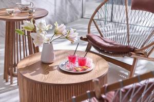 a table with two drinks and a vase with flowers at Silverland Mây Hotel in Ho Chi Minh City