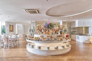 Silverland Mây Hotel في مدينة هوشي منه: غرفة مع طاولة مع عرض للطعام