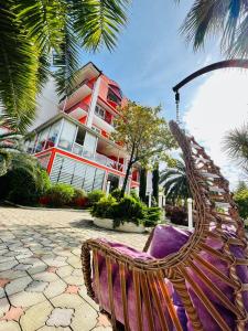 a rattan chair in front of a building at Hotel Albatros in Ureki