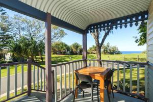 een veranda met een houten tafel en een stoel bij Reflections Corindi Beach - Holiday Park in Corindi
