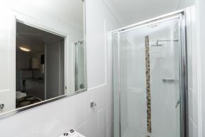 een badkamer met een douche en een spiegel bij Reflections Corindi Beach - Holiday Park in Corindi