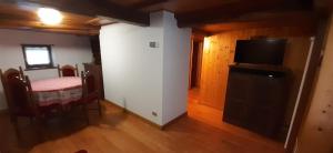 a living room with a dining table and a television at Da Ivana in Alagna Valsesia