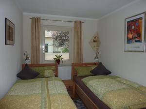 1 dormitorio con 2 camas y ventana en Haus Edelsbergblick, en Nesselwang