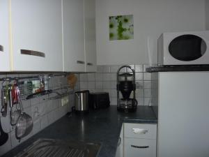 a kitchen with white cabinets and a black counter top at Haus Edelsbergblick in Nesselwang