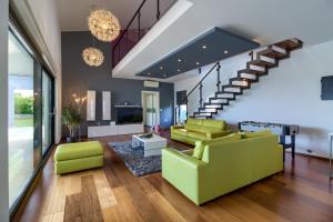 ein Wohnzimmer mit einer grünen Couch und einer Treppe in der Unterkunft Beautiful villa Eva with private pool near the beach in Šišan