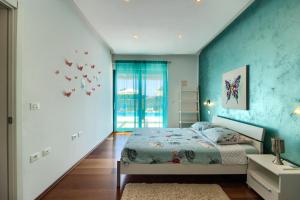 ein Schlafzimmer mit einem Bett und einer blauen Wand in der Unterkunft Beautiful villa Eva with private pool near the beach in Šišan + 72 Fotos