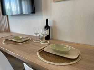 una mesa con una botella de vino y dos copas en VERA VITA APARTMENTS en Skala Rachoniou