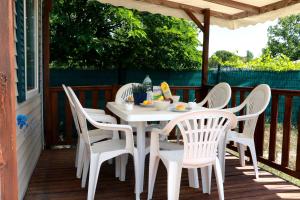 a white table and chairs on a porch at Mobilhome «des Salines» * 6 personnes *3 Chambres in Sigean