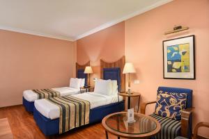 Postel nebo postele na pokoji v ubytování The Cama - A Sabarmati Riverfront Hotel