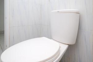 a bathroom with a white toilet in a room at RedDoorz Syariah at Griya Merbotan Demak in Demak