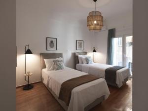 a bedroom with two beds and a chandelier at Aiginitou6 in Athens
