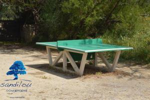 a green ping pong table sitting on the ground at Mobilhome «des Salines» * 6 personnes *3 Chambres in Sigean