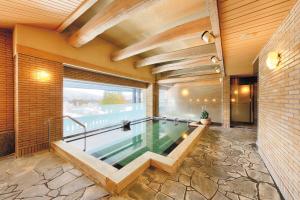 una piscina in una casa con una grande finestra di Sun Members Hirugano a Gujo