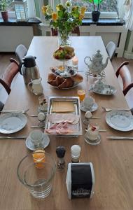una mesa con comida y platos. en B&B Het Oude Doktershuys, 