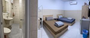 una piccola camera con due letti e un bagno di HeMei Homestay a Ho-mei