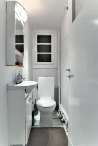 a white bathroom with a toilet and a sink at Kolonaki Jewel 1st floor feel like home properties in Athens